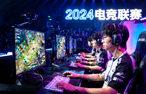 电竞赛事舞台现场，选手在电脑前进行对战